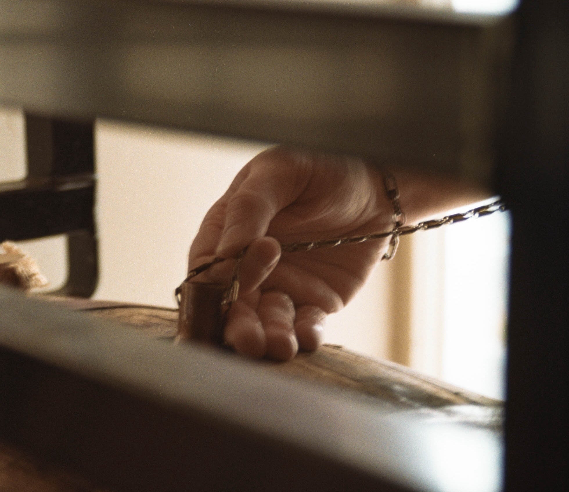 Image of a person using a copper dog tool to pull a sample of aged american single malt whiskey out of an oak barrel.