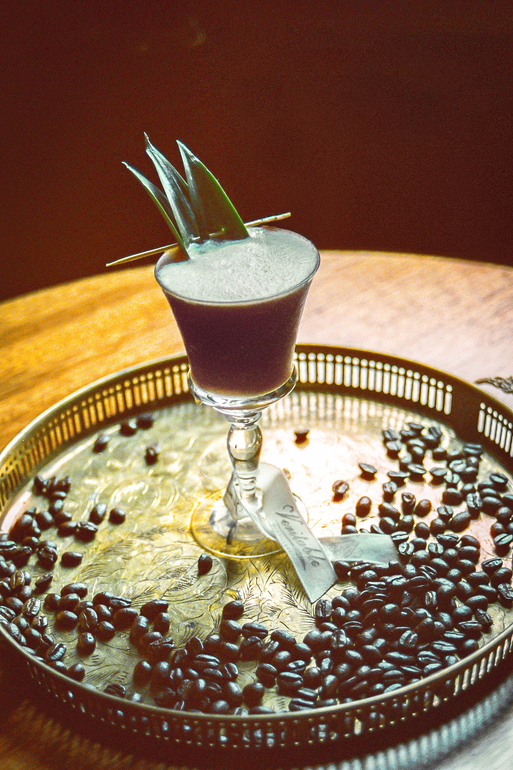 Image of Cafe Cabana cocktail, a tiki style cocktail using rum, coffee liqueur, velvet falernum, espresso, pineapple juice, cream of coconut and lemon juice. 