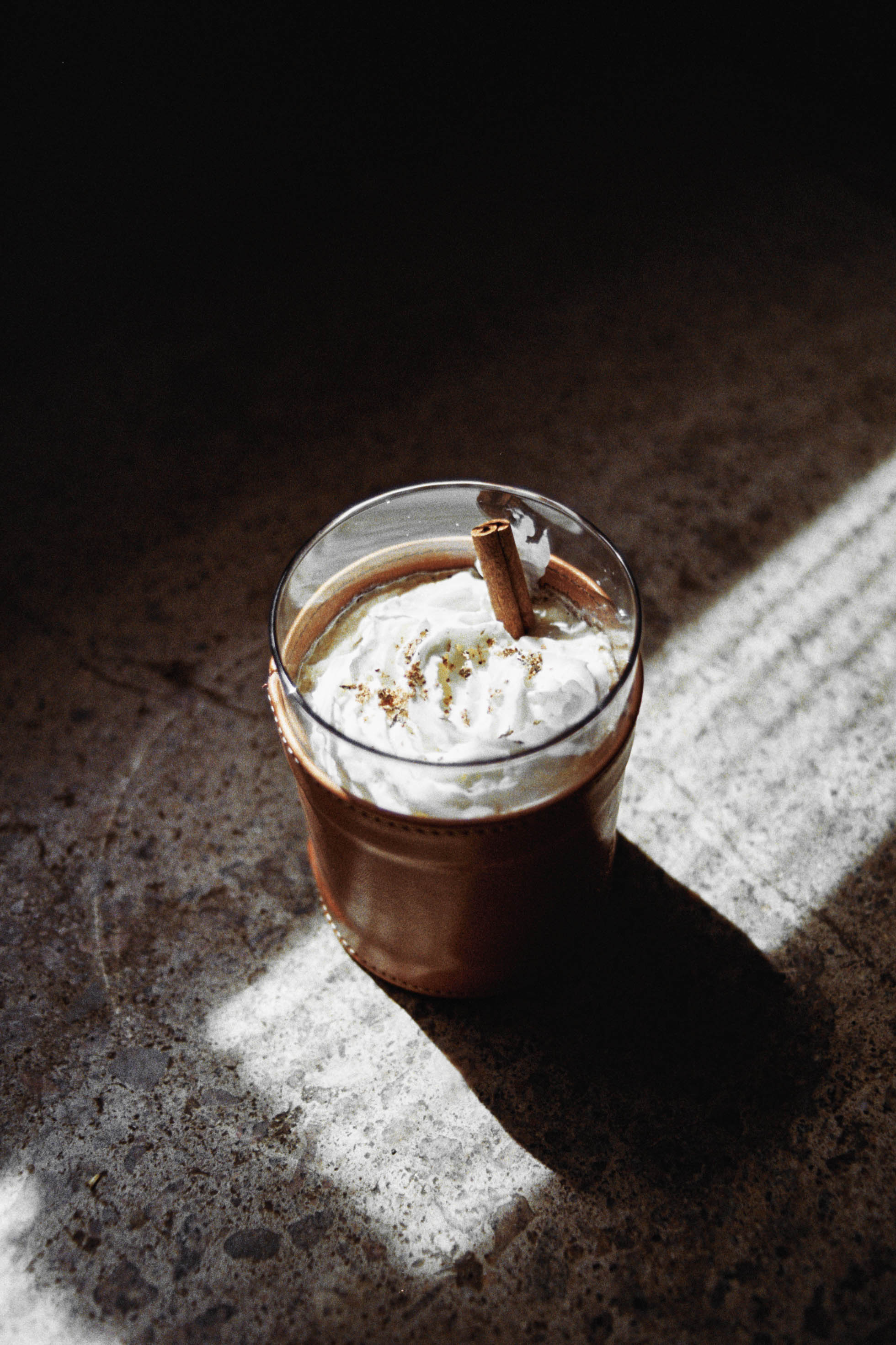 Close up image of the Captains Coffee cocktail using Ship's Bell Bourbon, Coffee Liqueur and topped with whipped cream and cinnamon.