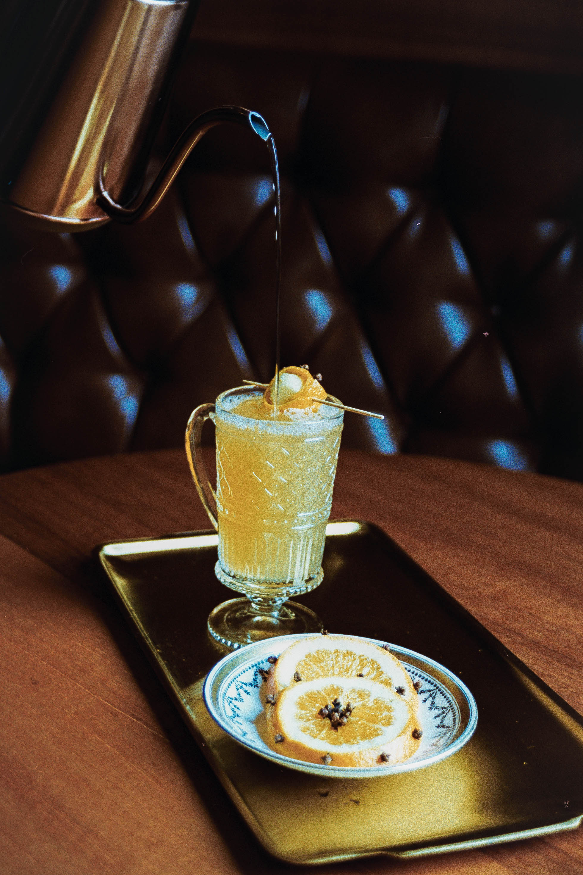 Harvest Moon Mule cocktail with orange peel garnish and clove,