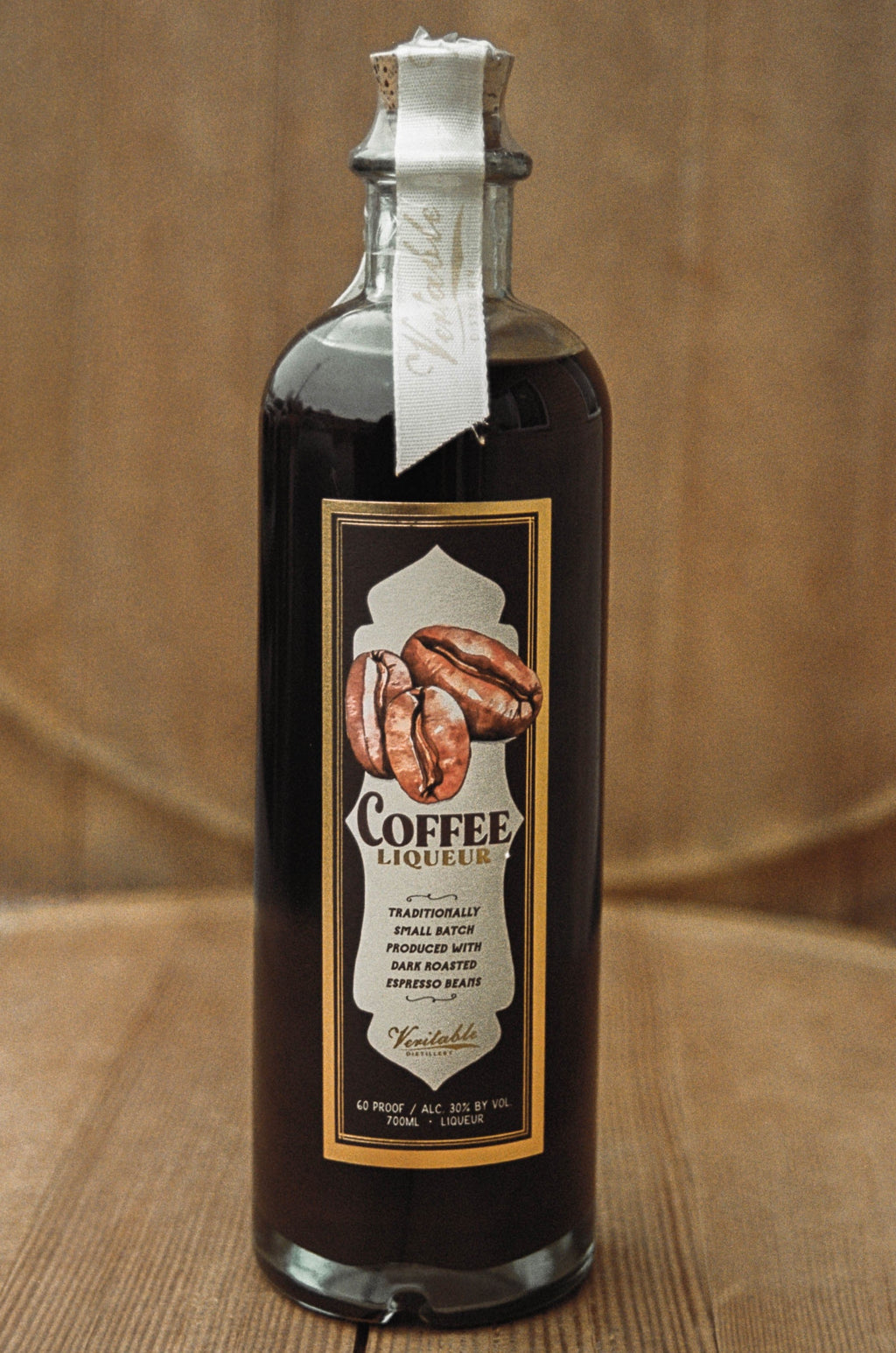 Image of veritable coffee liqueur bottle on wood background, waiting to be mixed into an espresso martini.