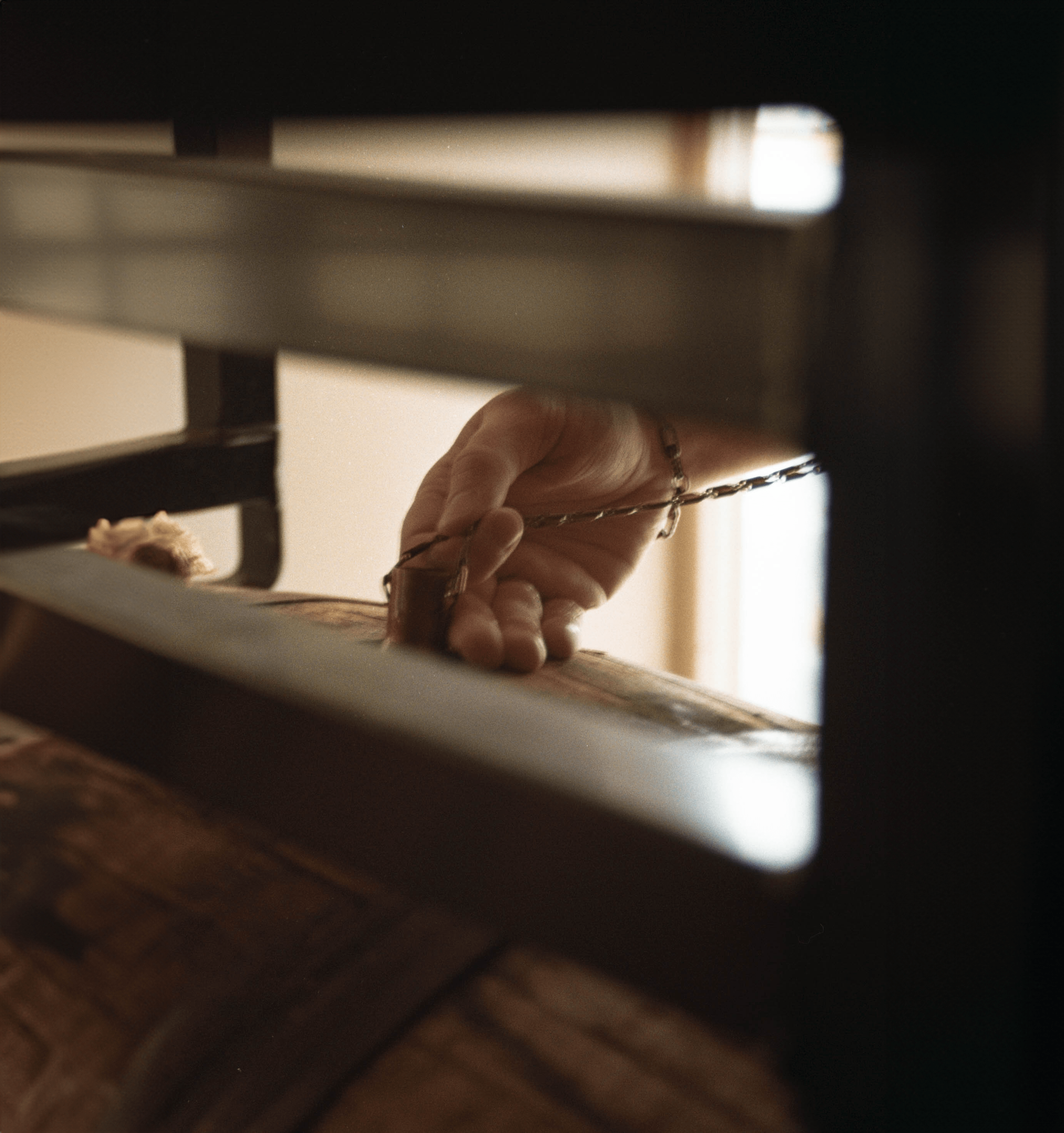 Image of a person using a copper dog tool to pull a sample of aged american single malt whiskey out of an oak barrel.